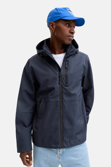 Veste courte bleue par ORIGINALS BY JACK & JONES, avec capuche et fermeture éclair, portée avec un t-shirt blanc et une casquette bleue.