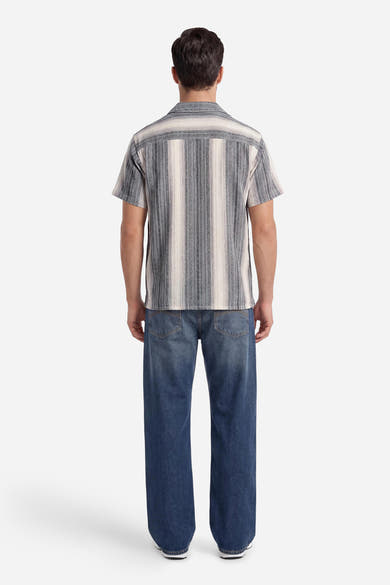 Chemise à manches courtes rayée grise, blanche et beige de ORIGINALS BY JACK & JONES, vue de dos sur un homme en jean bleu.