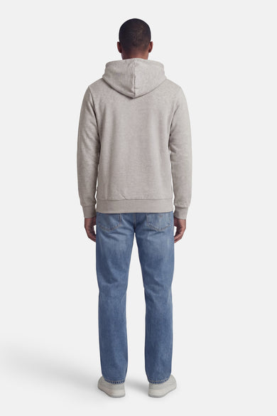 Sweat à capuche gris de PREMIUM by JACK & JONES, avec manches longues, porté avec un jean bleu et des baskets grises.