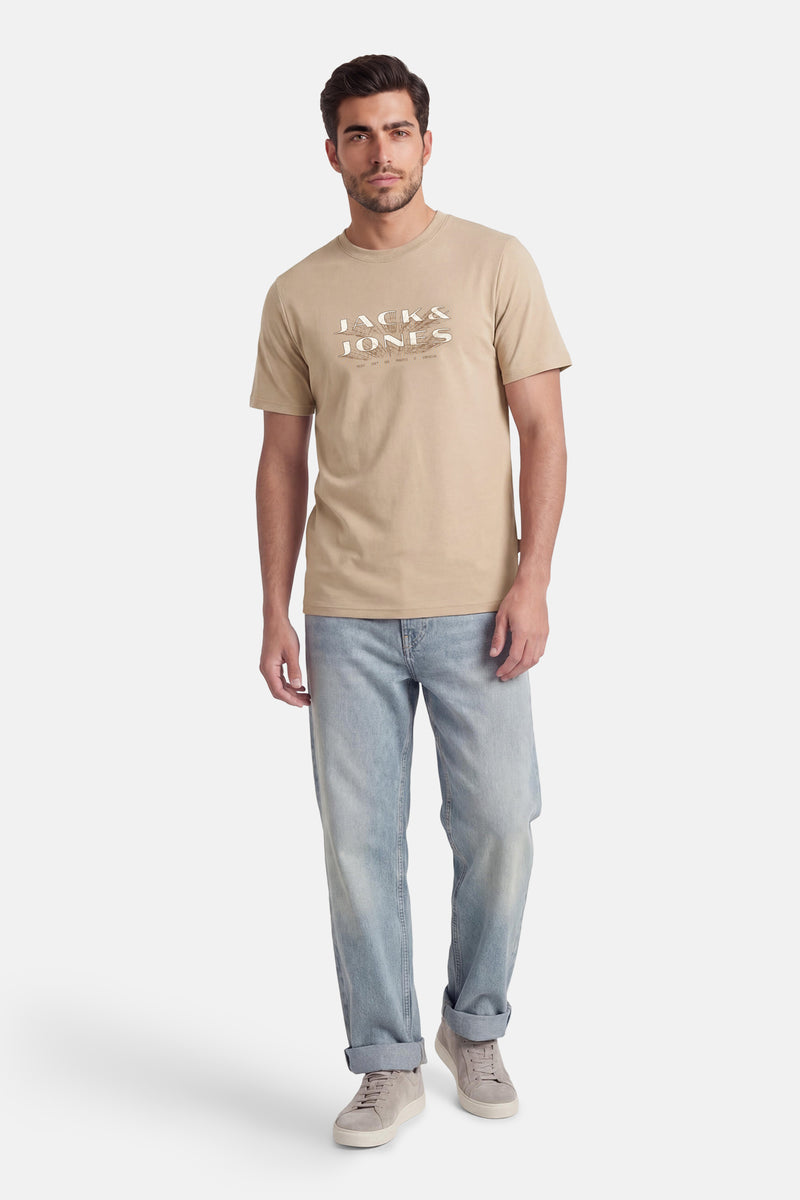 Beige T-shirt met korte mouwen van PREMIUM by JACK & JONES, gedragen met een spijkerbroek en sneakers.