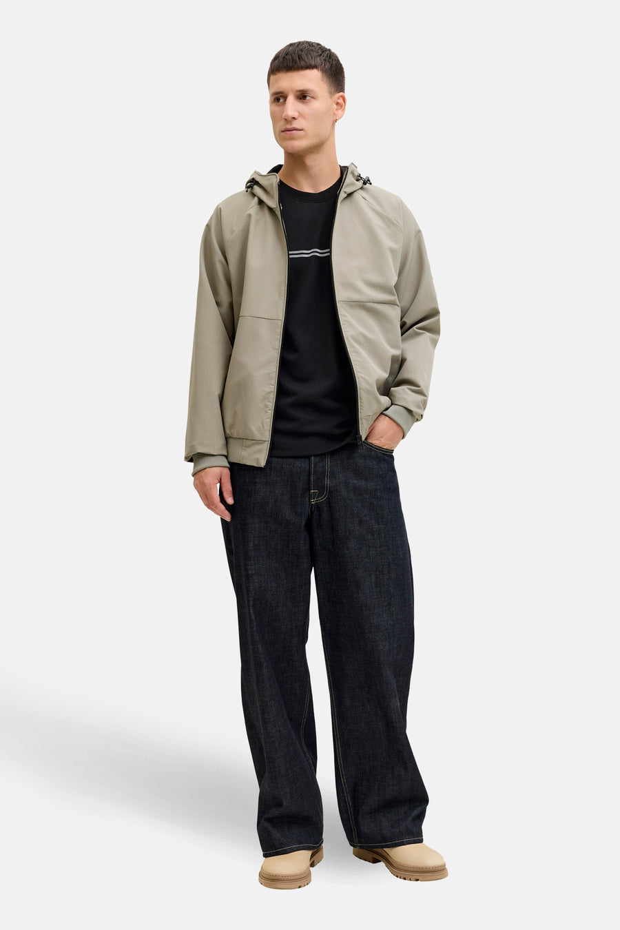T-shirt noir à manches courtes de JACK & JONES, porté avec un blouson et un jean amples.