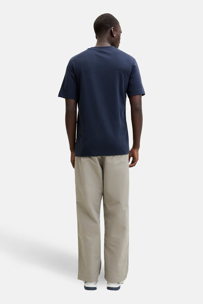 Blauw T-shirt met korte mouwen van JACK & JONES, van achteren gezien, gedragen met een wijde beige broek.