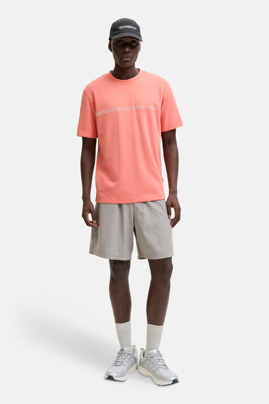 T-shirt orange de JACK & JONES avec lignes et inscription sur la poitrine, porté par un homme en short gris.