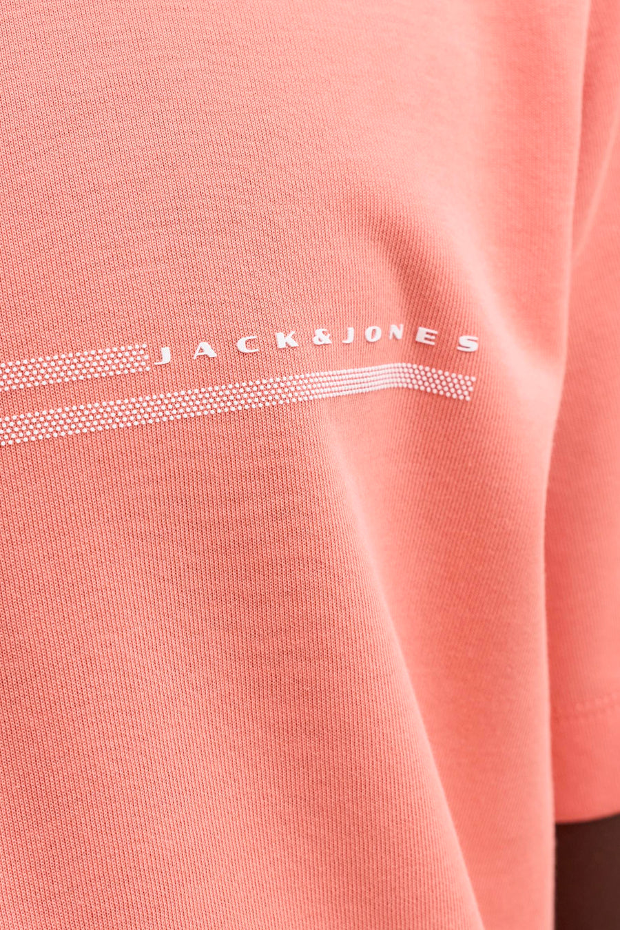 T-shirt orange de JACK & JONES avec logo blanc et lignes pointillées, texture côtelée.