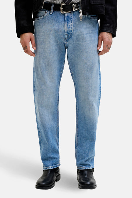 Taps toelopende jeans van lichtblauw denim van Jack & Jones Jeans Intelligence, gedragen met een zwart jasje en een gestreepte stropdas.