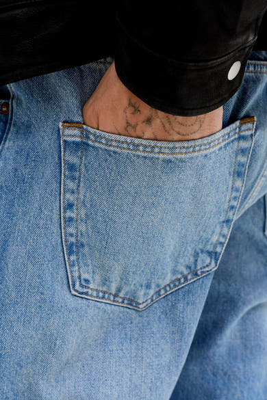 Jean fuselé en denim bleu clair de Jack & Jones Jeans Intelligence, avec une main dans la poche arrière.