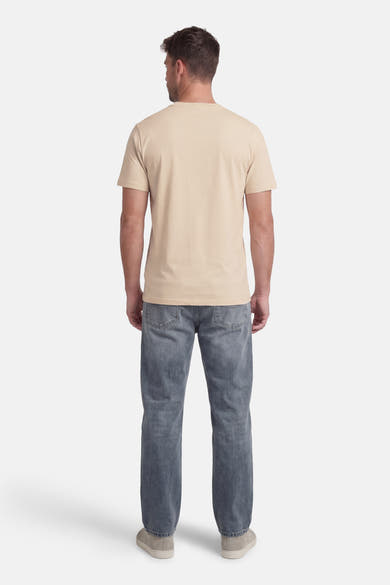 T-shirt à manches courtes beige par ORIGINALS BY JACK & JONES, porté avec un jean bleu et des chaussures décontractées, vue de dos.
