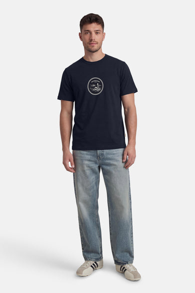 Blauw T-shirt met korte mouwen van ORIGINALS BY JACK & JONES met een print op de borst, gedragen met een spijkerbroek en sneakers.
