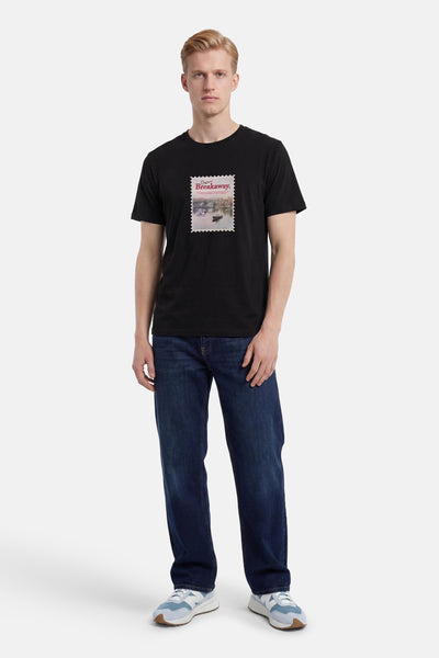 T-shirt noir de ORIGINALS BY JACK & JONES avec imprimé graphique "Breakaway" de timbre, porté avec un jean bleu.