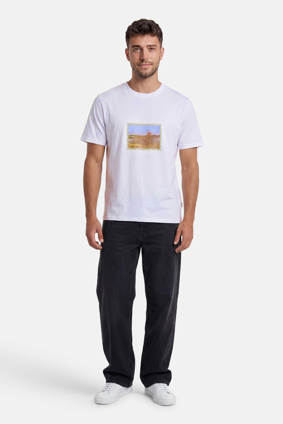 T-shirt blanc de la marque ORIGINALS BY JACK & JONES avec motif timbre paysage et texte, porté avec un jean foncé et des baskets blanches.