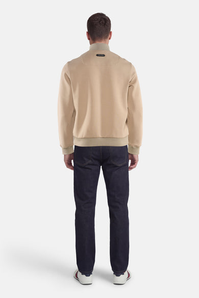 Veste beige de PREMIUM by JACK & JONES, vue de dos, portée avec un jean bleu foncé et des baskets blanches.
