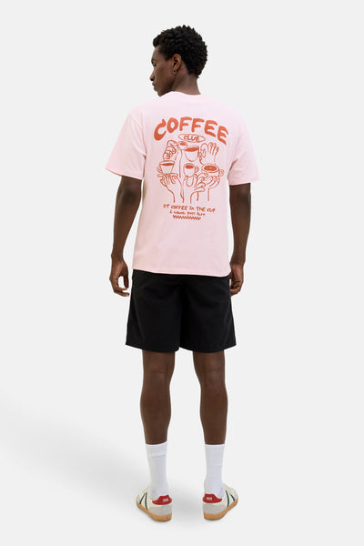 T-shirt rose à manches courtes de ORIGINALS BY JACK & JONES avec un imprimé graphique au dos, porté avec un short noir.