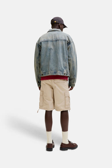 Short beige de JACK & JONES, porté avec une veste en jean et des chaussures marron.