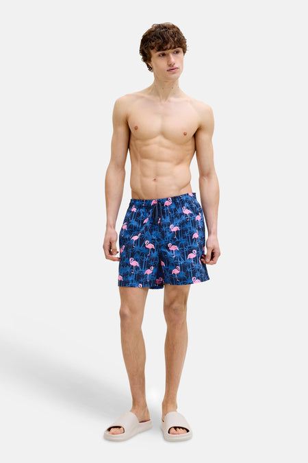 Short de bain bleu à motif de flamants roses de JACK & JONES JEANS INTELLIGENCE, portés avec des sandales beiges.