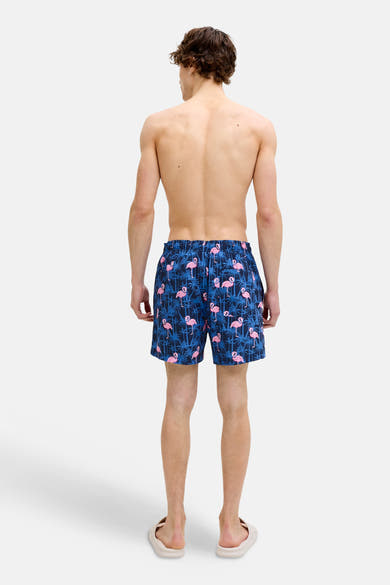 Blauwe zwembroek JACK & JONES JEANS INTELLIGENCE met roze flamingo-print, gedragen door een man van achteren gezien.