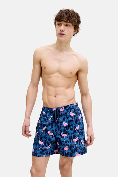 Blauwe zwembroek met roze flamingo-print van JACK & JONES JEANS INTELLIGENCE, gedragen door een man zonder shirt.