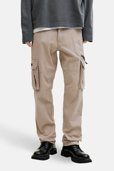 Beige cargobroek van JACK & JONES, met cargozakken en zwarte veterschoenen.