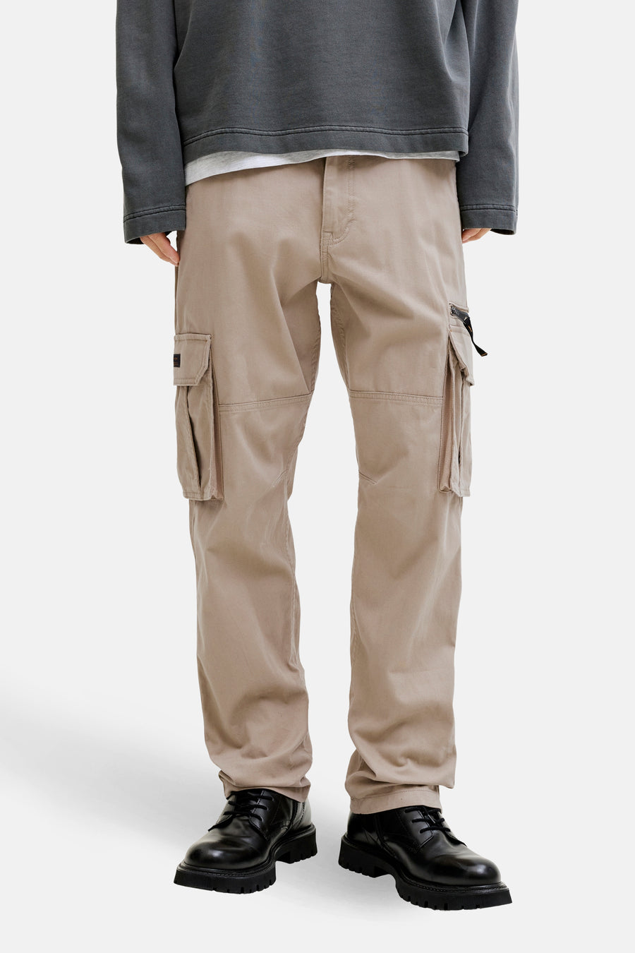 Beige cargobroek van JACK & JONES, met cargozakken en zwarte veterschoenen.