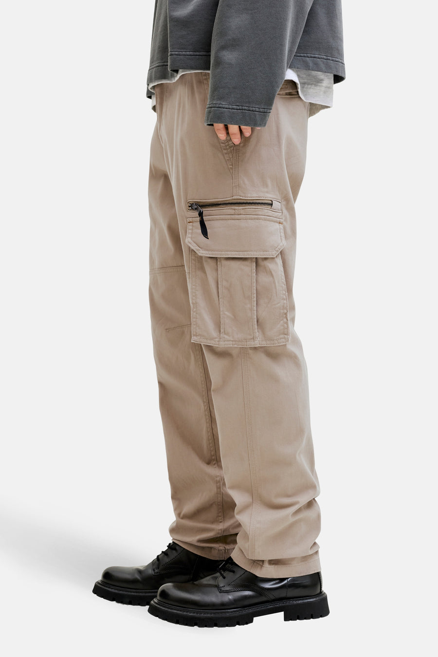 Beige cargobroek van JACK & JONES, met zijzakken met rits, gedragen met zwarte schoenen.