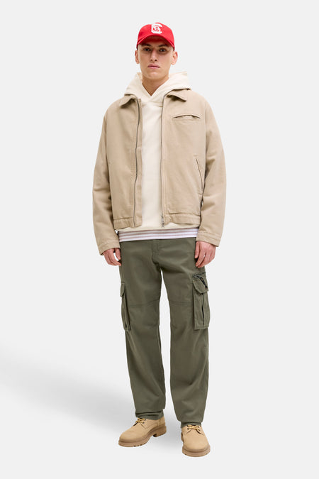 Pantalon cargo olive de JACK & JONES, avec poches multiples et coupe décontractée, porté avec un blouson et un sweat à capuche.