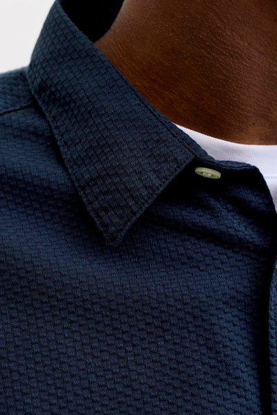 Chemise bleue à manches courtes de JACK & JONES, avec un motif texturé et un col boutonné.