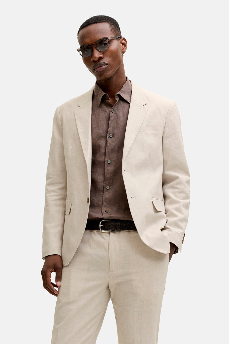 Blazer écru de PREMIUM by JACK & JONES, en tissu léger, porté ouvert avec une chemise marron et un pantalon assorti.