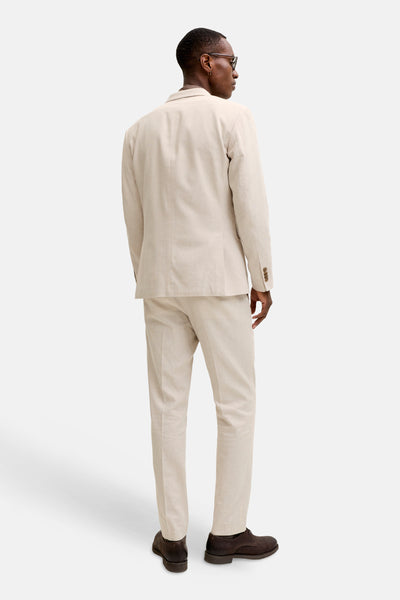 Blazer écru de PREMIUM by JACK & JONES, vu de dos, en tissu texturé, porté avec un pantalon assorti et des chaussures marron foncé.