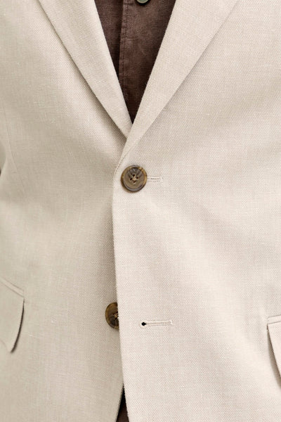 Blazer écru de PREMIUM by JACK & JONES en tissu texturé, boutonné sur une chemise marron.