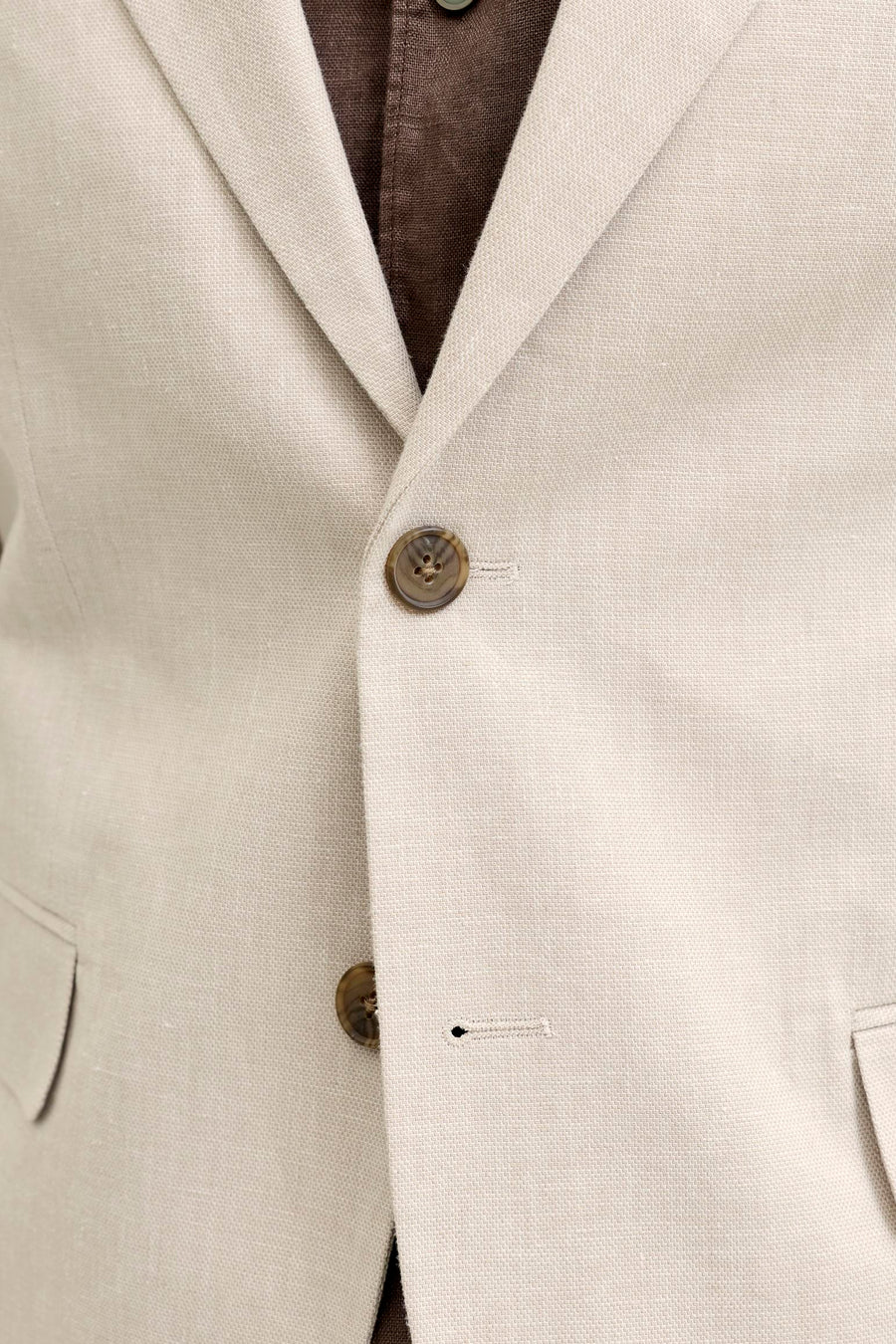 Ecru blazer van PREMIUM by JACK & JONES in getextureerde stof, geknoopt over een bruin overhemd.