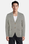 Blazer vert en tissu texturé de PREMIUM by JACK & JONES, à revers crantés, deux boutons et poches plaquées, porté sur un débardeur blanc.