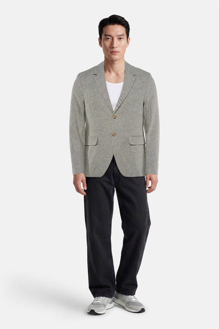 Blazer vert clair chiné de PREMIUM by JACK & JONES à deux boutons, porté sur un t-shirt blanc, un pantalon noir et des baskets grises.