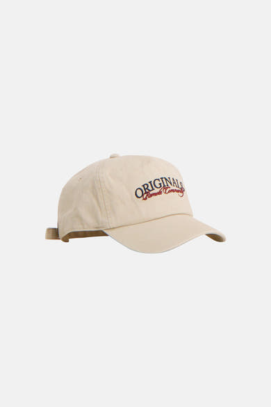 Casquette écru de ACCESSORIES BY JACK & JONES, brodée "ORIGINALS" en bleu et "Remote Community" en rouge, vue de côté.