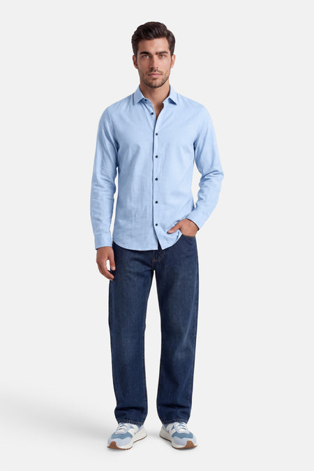 Chemise à manches longues bleu clair de la collection PREMIUM by JACK & JONES, portée avec un jean et des baskets.