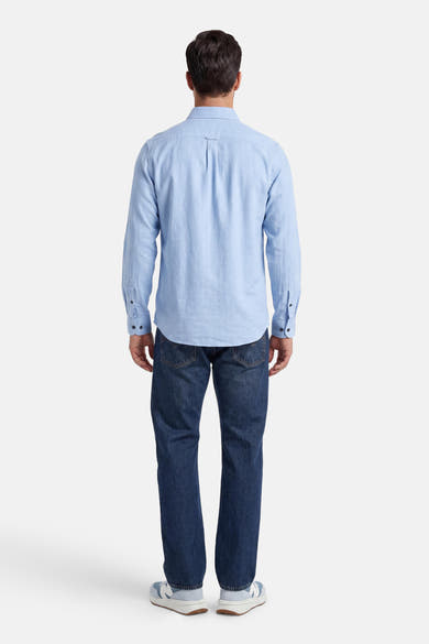 Chemise bleu clair texturée à manches longues de PREMIUM by JACK & JONES, portée de dos avec un jean et des baskets.
