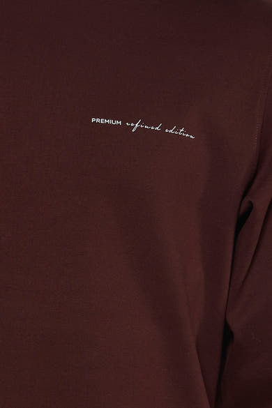 Brown O-neck sweatshirt with white embroidered text "PREMIUM refined edition" on chest, close-up front view
