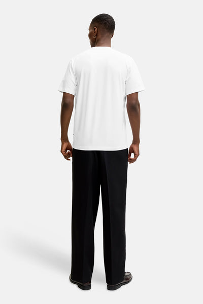 Wit T-shirt met korte mouwen van PREMIUM by JACK & JONES, gedragen met een zwarte broek en leren schoenen.