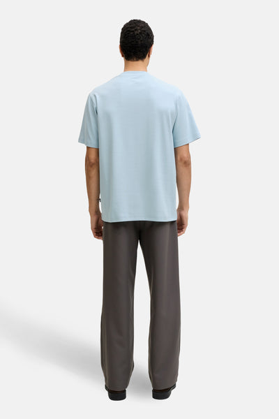 Blauw T-shirt met korte mouwen, van PREMIUM by JACK & JONES, gedragen met een wijde antracietgrijze broek.