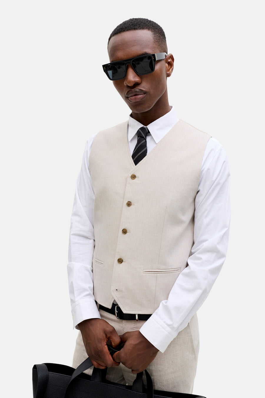 Ecru gilet van PREMIUM by JACK & JONES, in getextureerde stof met knopen, gedragen over wit overhemd en das.