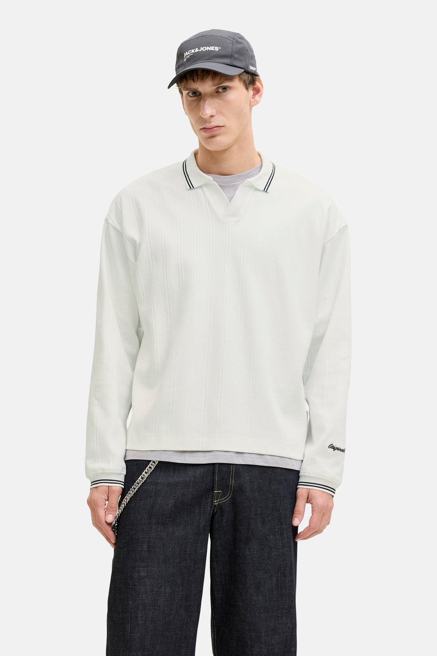 Witte rondehals sweatshirt van Originals by Jack & Jones, gedragen met een geruit jasje en een donkere broek.