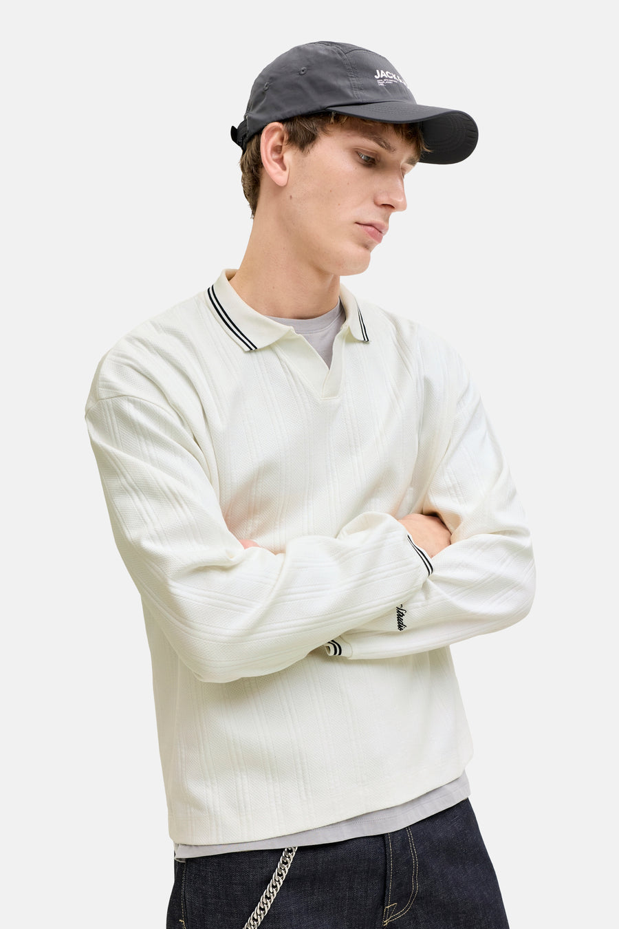 Witte polo met wafelstructuur van ORIGINALS BY JACK & JONES, gedragen met een pet en een spijkerbroek.