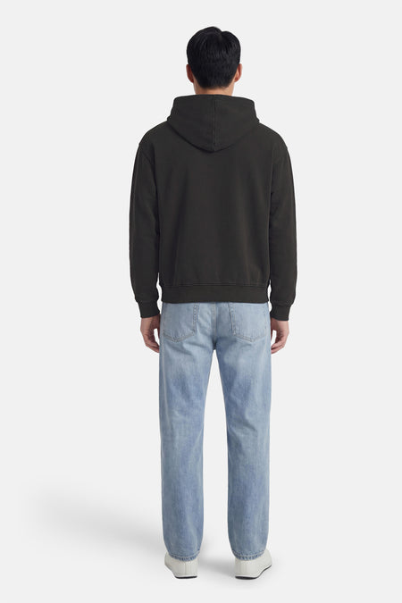Zwarte rondehals sweatshirt van PREMIUM by JACK & JONES, gedragen met een lichtblauwe jeans en witte schoenen, achterzicht.