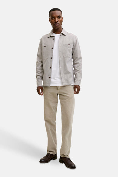 T-shirt blanc à manches courtes de PREMIUM BLUE by JACK & JONES porté avec une chemise et un pantalon beige.