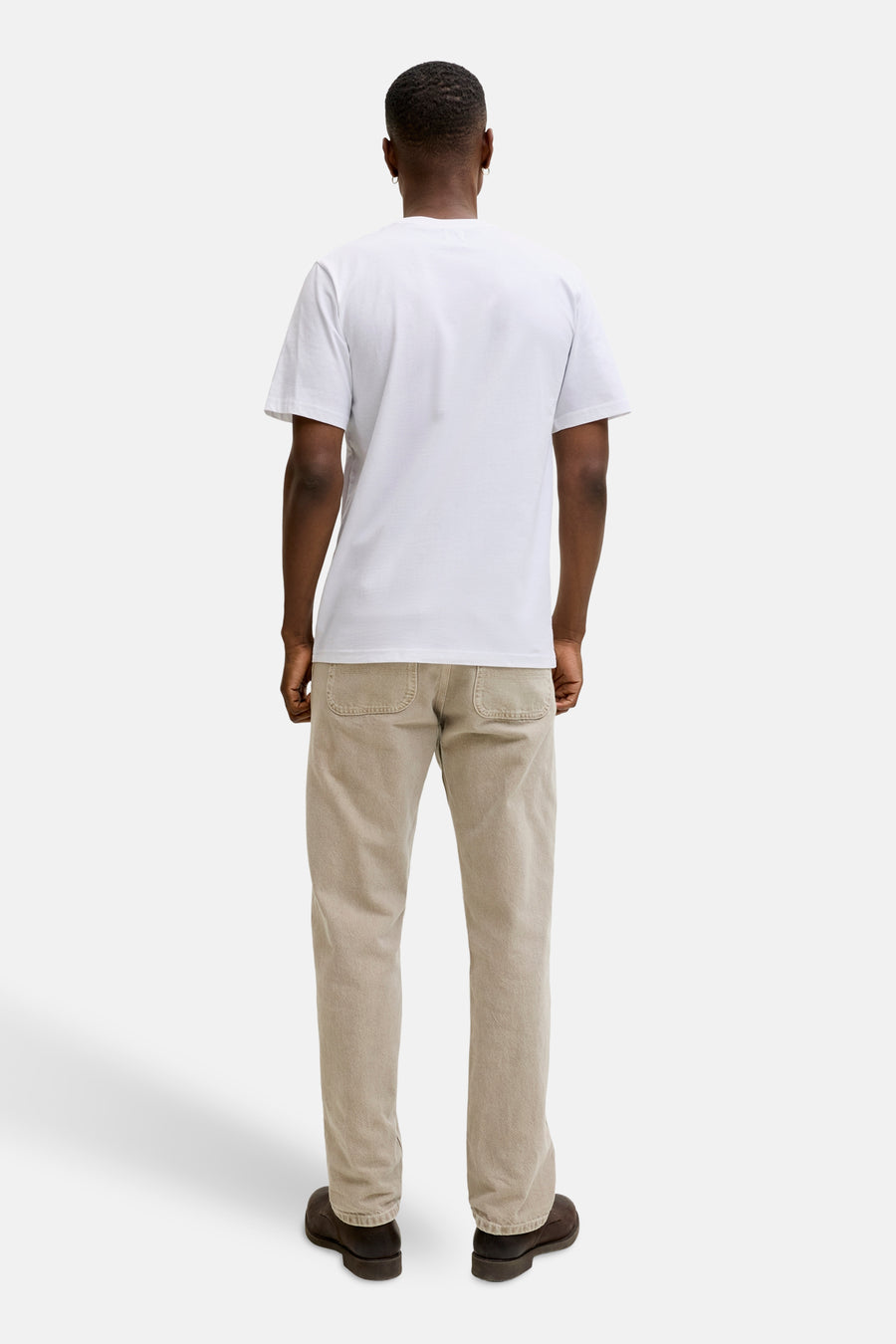 Wit T-shirt met korte mouwen van PREMIUM BLUE by JACK & JONES, van achteren gezien, gedragen met een beige broek en bruine schoenen.