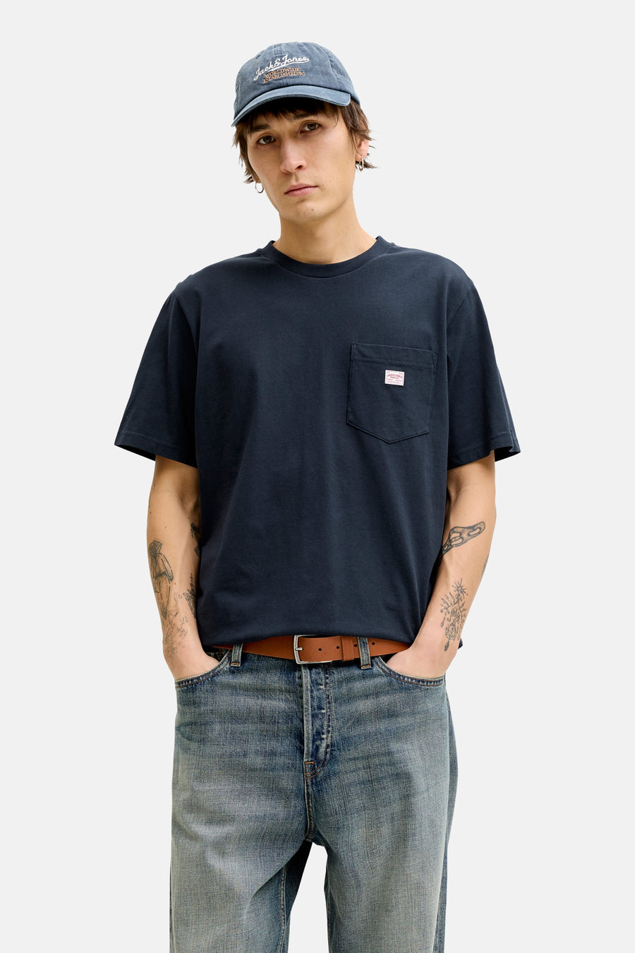 Blauw T-shirt met korte mouwen van PREMIUM BLUE by JACK & JONES, gedragen met een verbleekte spijkerbroek en een pet.