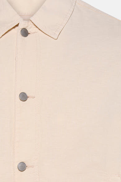 Veste beige en tissu texturé de PREMIUM by JACK & JONES, avec col classique et boutons métalliques gravés sur le devant.