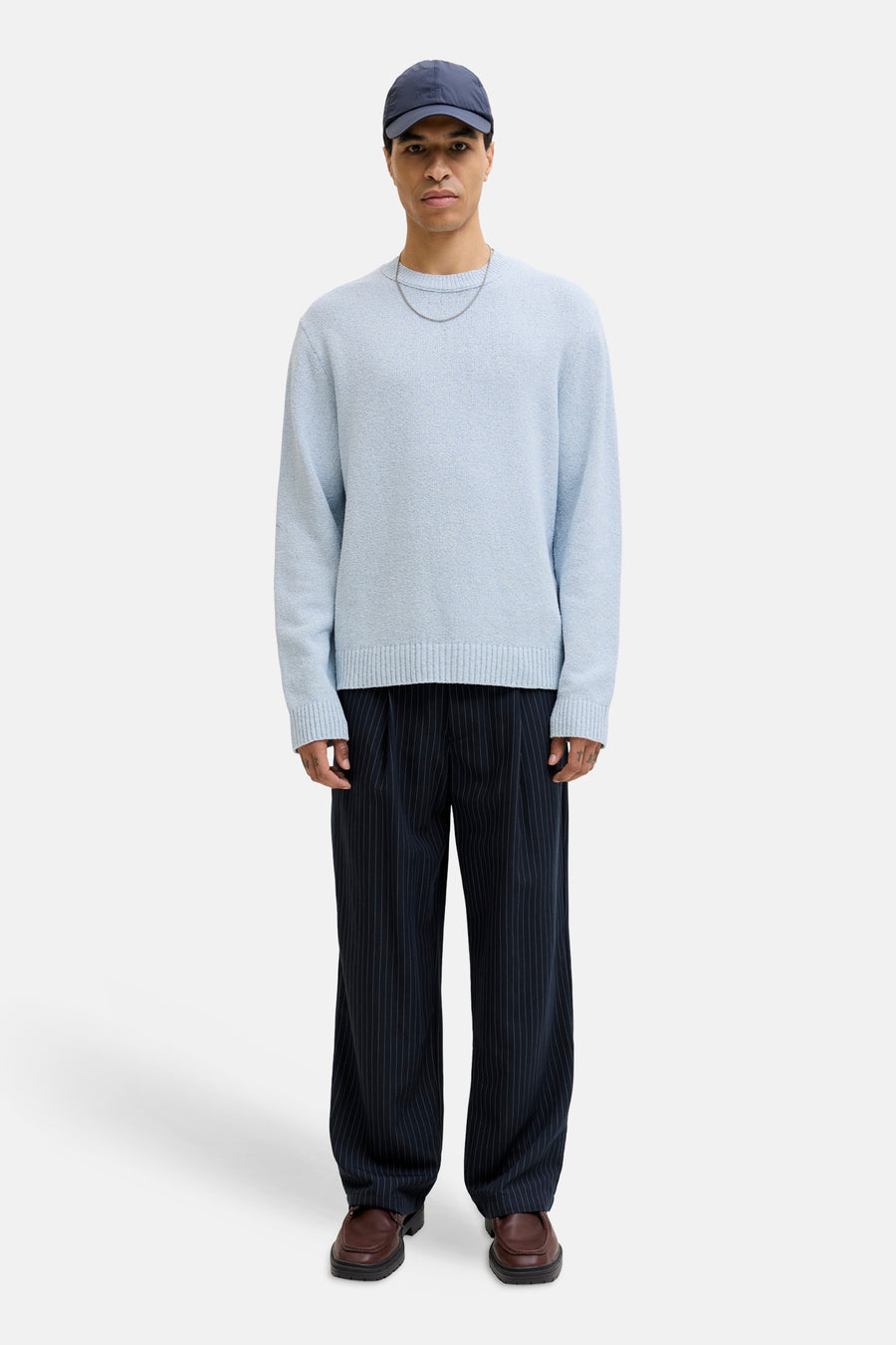 Pull à col rond bleu d'ORIGINALS BY JACK & JONES, porté avec un pantalon à rayures et des mocassins.