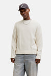 Ecru ronde hals trui van ORIGINALS BY JACK & JONES gedragen met een zwart leren jasje en een wijde jeans.