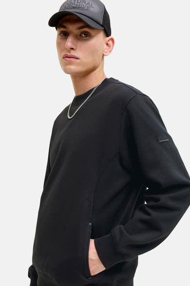 Zwarte rondehals sweatshirt van JACK & JONES met een logo-badge op de mouw en een kettingkraag.