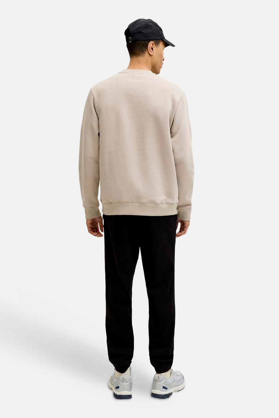 Beige sweater van JACK & JONES, gedragen met een zwarte broek en grijze sneakers, achtergezicht.
