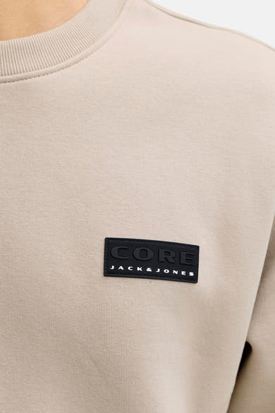 Beige sweatshirt van JACK & JONES, met een zwart CORE-logopatch op de borst.